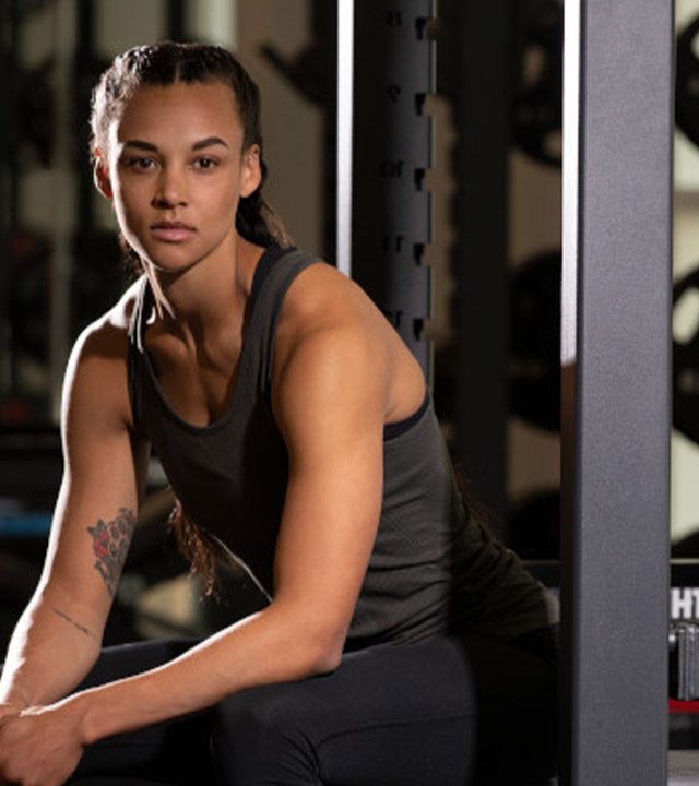 Woman Resting on Gym Equipment WeightSpace